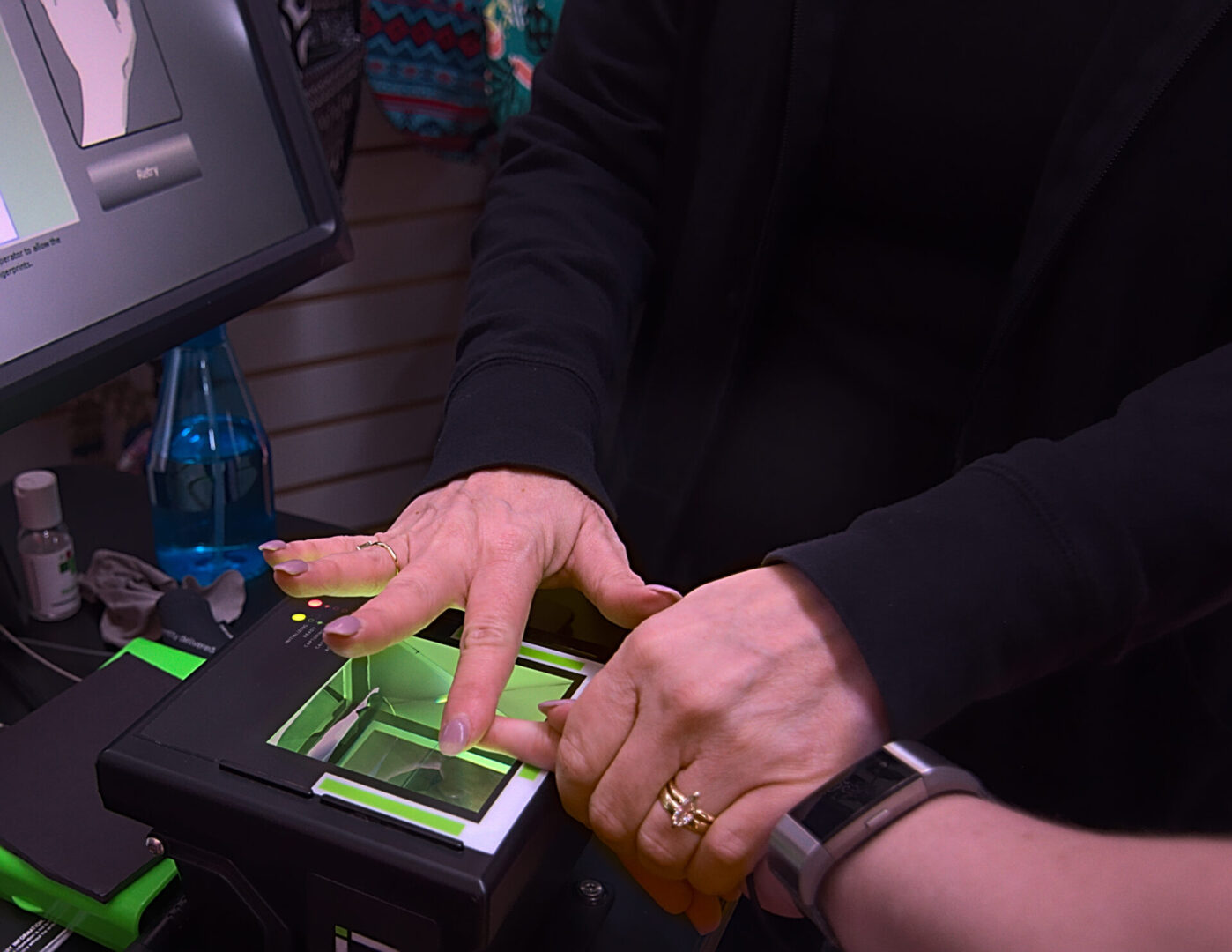 A young woman gets her finger prints scanned live as a requirement to getting a job as a travel occupational therapist.